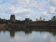 The big daddy: Angkor Wat. There is a gigantic moat around the entire complex; a stone "Rainbow Bridge" leads in from the west (just visible on the left). Angkor is distinctive, in fact, for facing west rather than east; there is no consensus as to why this was done, though there are several theories.