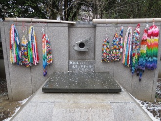 This memorial in Tokyo's Ueno park has a flame lit from embers from Hiroshima and Nagasaki. The colorful garlands flanking it are made of thousands of origami paper cranes.